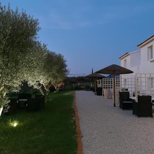 un sentiero con sedie e un ombrellone in un cortile di Boho Sisi Resort - Poolside Oasis & Garden Vibes ad Ágios Nikólaos