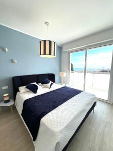 a bedroom with a large bed and a large window at Appartamento Gocce di sole in Pietra Ligure