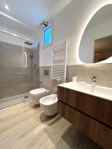 een badkamer met 2 wastafels, een toilet en een douche bij Appartamento Gocce di sole in Pietra Ligure