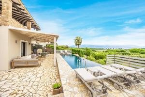 a villa with a swimming pool and a patio at Villa Antinoti in Agía Aikateríni