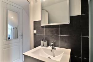 a bathroom with a white sink and a mirror at Les Apparts du Pont Vert - lit double - WiFi - tout inclus - 4 in Troyes +3 photos
