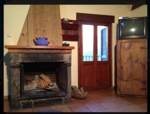 a living room with a fireplace and a tv at La era de Satue in Fanlo del Valle de Vío