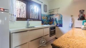 una cucina con un lavello e un bancone di Casa na Praia de Mucugê - Arraial D'ajuda - Bahia - 40m da praia - Ar condicionado - vaga de estacionamento - Wifi a Arraial d'Ajuda
