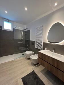 a bathroom with two sinks and a toilet and a shower at Appartamento Gocce di sole in Pietra Ligure +12 photos