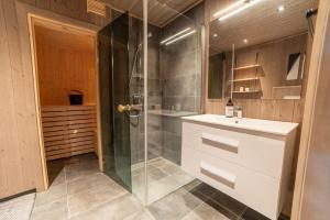 y baño con ducha, lavabo y cabina de ducha acristalada. en Sunnmøre Getaway, en Sykkylven 49 fotos más