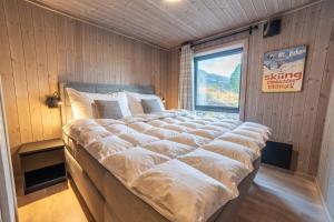 una cama grande en una habitación con ventana en Sunnmøre Getaway, en Sykkylven