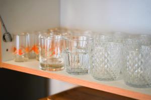 a row of glasses sitting on a shelf at K-HAUS - English Speaking, Contactless-Self Check In Accomodation in Děčín