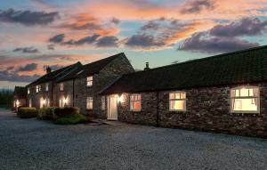 ベバリーにあるHigh Barn 6 bedroomsの日没を背景にしたレンガ造りの建物