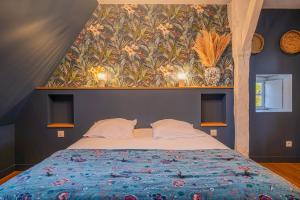 una camera da letto con un letto grande con carta da parati floreale di Le Grand Monnet - Parc - 20 personnes - Rêve au Mans a Coulaines