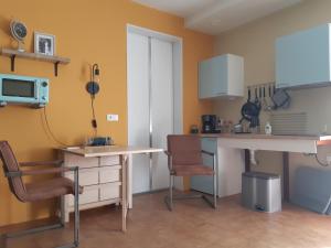 a kitchen with a desk and a table and a chair at Studio De Logeerruimte in Beilen