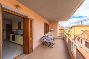 a balcony with a table and a kitchen on it at casa illaria in Olbia