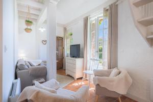 a living room with two chairs and a television at Gîte du Rouard in Camiers