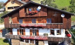 a wooden house with flowers in the windows at Lü de Terza in San Vigilio Di Marebbe