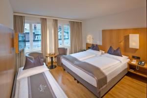 pokój hotelowy z dużym łóżkiem i telewizorem w obiekcie Hotel Maximilian - Stadthaus Penz w mieście Innsbruck