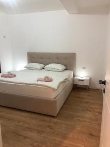 ein weißes Bett mit zwei Kissen darauf im Schlafzimmer in der Unterkunft City & Canyon - Modern Comfort in Çorovodë