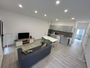 a living room with a couch and a table and a kitchen at Casa Jonhy in Faro