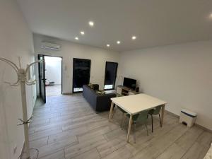 una sala de estar con una mesa y un sofá en Casa Jonhy, en Faro