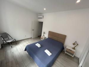 Un dormitorio con una cama azul con dos toallas encima. en Casa Jonhy, en Faro