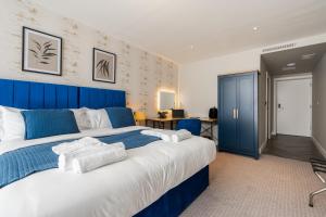 a large bedroom with a blue and white bed at Above Hotels in Burnley