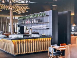 eine Bar in einem Restaurant mit einem Tisch und Stühlen in der Unterkunft HagenStay Mittelstadt 1 in Hagen