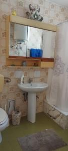 Un baño con lavabo, inodoro y espejo. en La Petra, en Caltabellotta