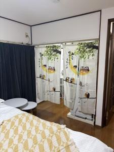 a bedroom with a bed and curtains with fruit on them at Yui HOSTEL in Tokyo