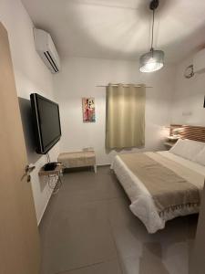 a bedroom with a bed and a flat screen tv at Sea pearl tower in Netanya +23 photos