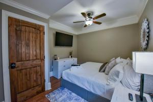 a bedroom with a bed with a ceiling fan and a door at Big Al's Den in Tuscaloosa