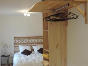 une chambre avec un lit blanc avec une échelle superposée en bois dans l'établissement La Maison De Pierre, à La Chapelle-de-la-Tour