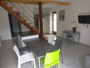 une cuisine et une salle à manger avec une table et des chaises dans l'établissement La Maison De Pierre, à La Chapelle-de-la-Tour