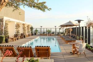 ein Pool in einem Hotel mit Stühlen und Tischen in der Unterkunft Rooftop Pool Modern 2BR, 2BA - Panoramic Hollywood views in Los Angeles