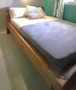a wooden bed with white sheets and pillows on it at Rio Sereno Haus mit Garten - Grenze zu Costa Rica in Río Sereno +8 photos