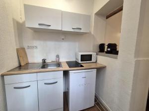 małą kuchnię ze zlewem i kuchenką mikrofalową w obiekcie Lisbonne - Bel appartement à Reims w mieście Reims