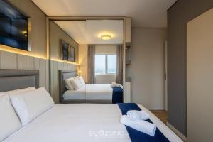 a hotel room with a bed and a mirror at Lindo Apartamento em Itajaí CTP1103 in Itajaí