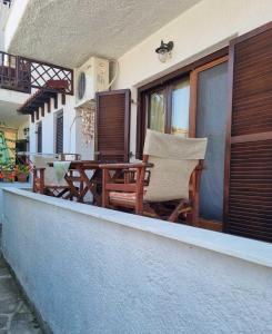 a balcony with a table and chairs on a house at Poly Nest House in Polychrono