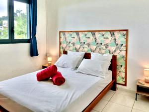 Un dormitorio con una cama con almohadas rojas. en Villa Charmante, Détente, Jacuzzi aux Avirons, en Les Avirons
