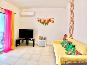 sala de estar con sofá amarillo y TV en Villa Charmante, Détente, Jacuzzi aux Avirons, en Les Avirons 4 fotos más