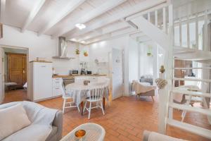 a living room with a table and a kitchen at Gîte du Rouard in Camiers