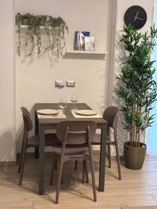 a dining room table and chairs with wine glasses at Cozy studio 700m from the Milan red metro in Sesto San Giovanni