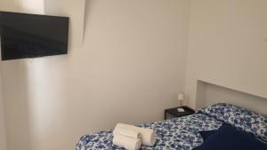 a bedroom with a bed with a tv on the wall at Casa Sofia in Vulcano