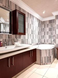 een badkamer met een wastafel en een ligbad bij Accommodation Front - Spectacular 2 Bedroom with Canal Views Near Ushaka in Durban