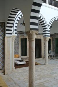 une cour avec des colonnes noires et blanches dans un bâtiment dans l'établissement Dar Ben Gacem, à Tunis
