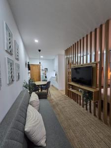 een woonkamer met een bank en een televisie bij Cantinho Averomar in Póvoa de Varzim