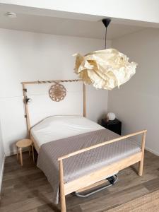 Un dormitorio con una cama con marco de madera. en Les chambres Saint-Roch, en Arles