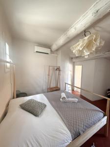 Un dormitorio con una gran cama blanca en una habitación. en Les chambres Saint-Roch, en Arles
