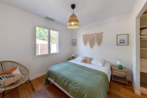 a bedroom with a bed and a chair in it at Villa Cazaline - Piscine Privée in La Teste-de-Buch