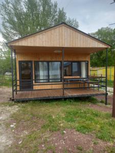una piccola casa con un grande ponte in un campo di Пляжный дом a Aghk'ilisa