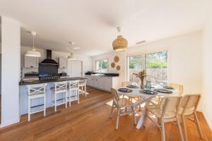 a kitchen and dining room with a table and chairs at Villa Cazaline - Piscine Privée in La Teste-de-Buch