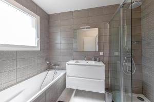a bathroom with a tub and a sink and a shower at Villa Cazaline - Piscine Privée in La Teste-de-Buch +12 photos