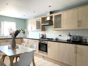 a kitchen with a table and a table and chairs at Cosy City Centre Townhouse in Elswick